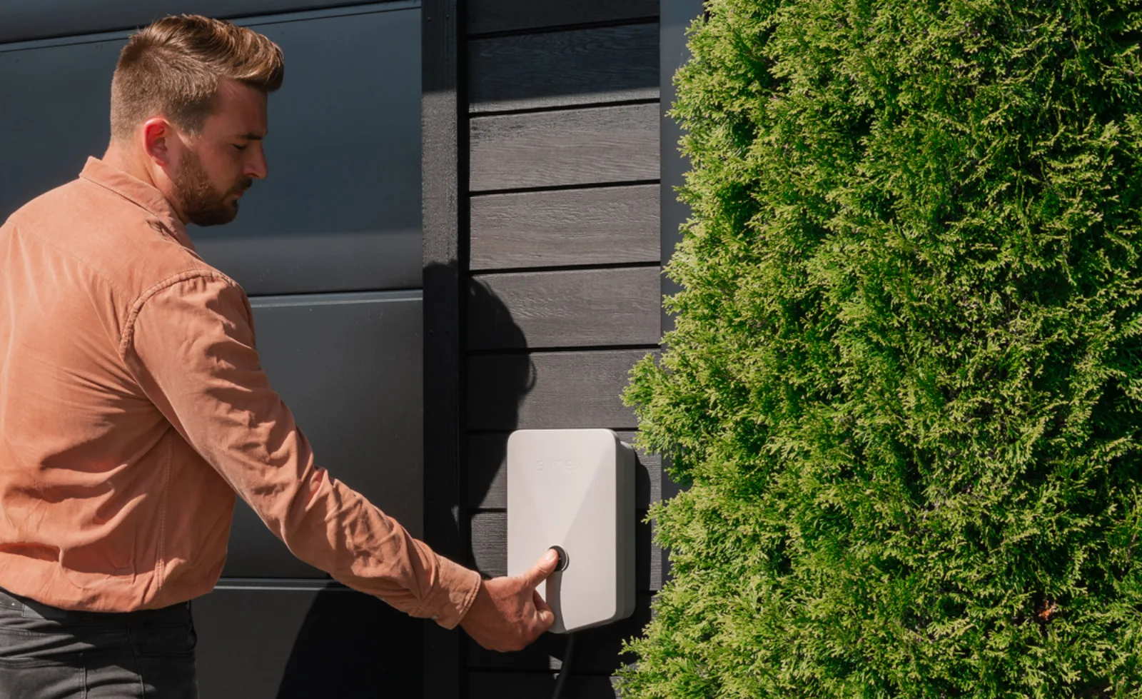 Man connecting Evnex EV charger cable at commercial building