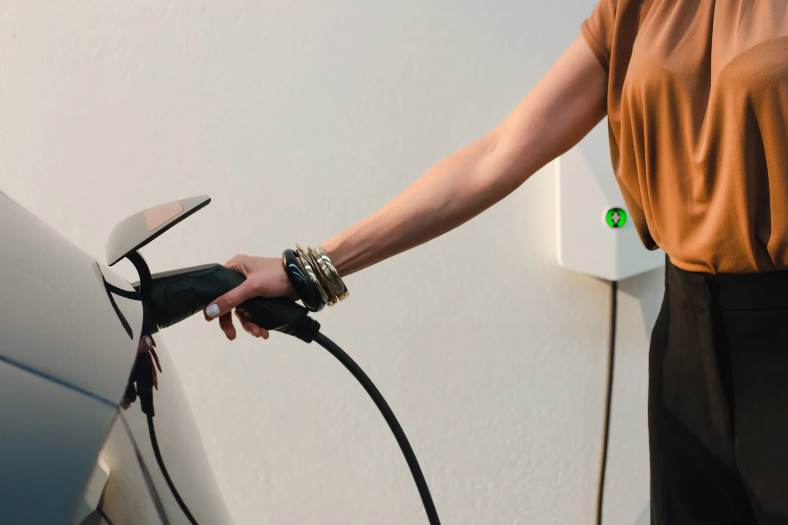 Close up of woman plugging Evnex charger into electric vehicle